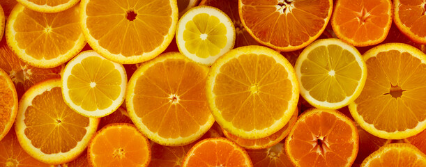Fototapeta na wymiar Citrus fruits slices assortment pattern background: orange, lemon and mandarin. Horizontal web banner. Slice of citrus flat lay texture.