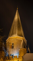 Fototapeta premium Drogenap historic medieval city entrance gate tower of Zutphen, The Netherlands, with its cants and corner turrets behind old facades