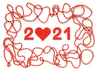 Red felt year numbers 2021 on white background. Zero in the shape of a heart. Red beads around. Valentine's Day. Review of the last year.