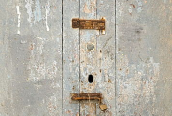 an aged wooden door, with rusty locks that suggests times gone by