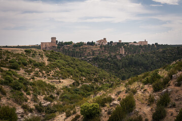 Fototapeta na wymiar Landscape with the fortified city of Alarcon with its watchtowers and the castle on top of the hill on a cloudy day, Cuenca, Spain