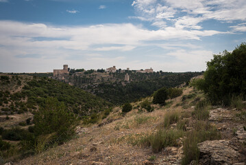 Fototapeta na wymiar Landscape with the fortified city of Alarcon with its watchtowers and the castle on top of the hill on a cloudy day, Cuenca, Spain
