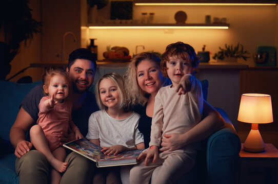 Happy Family Sitting Together At Cozy Home In The Evening