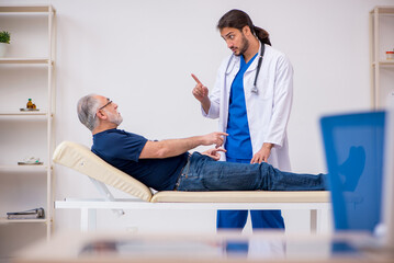 Obraz premium Old male patient visiting young male doctor chiropractor