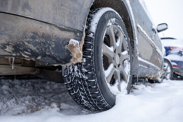 Winter tire. Car on snow road. Tires on snowy highway detail.