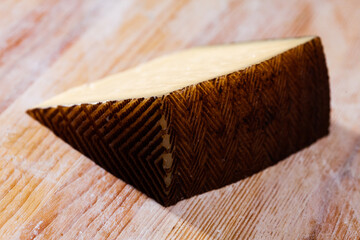 Slices of semi-hard cheese on wooden surface