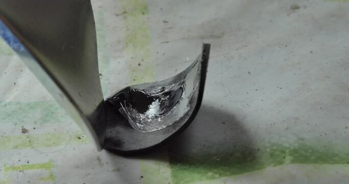 Bicycle repair. The master smears the glue evenly on the rubber patch to seal the camera of the bike. Closeup.