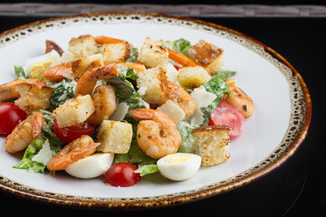 salad with shrimps, lettuce, cherry tomatoes, quail eggs and crispy rye croutons