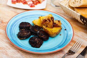 Fried rustic tasty blood sausage with potato served at plate, nobody