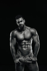 Fototapeta na wymiar Male fitness model Konstantin Kamynin posing shirtless on black background