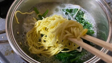 生麺を茹でてラーメンを調理中。家庭料理/庶民の食生活