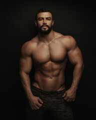 Fototapeta na wymiar Fitness handsome and shirtless man standing on black background