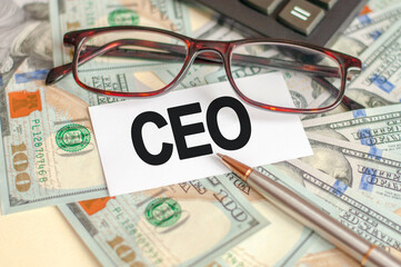 On the table are bills, a bundle of dollars and a sign on which it is written - CEO. Finance and economics concept.