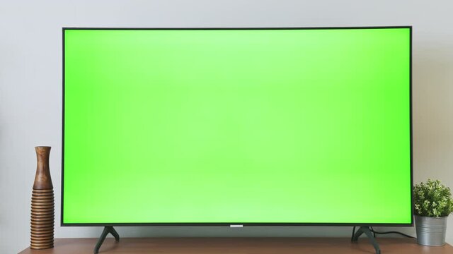 TV Green Screen in living room with tree and lamps. chroma key screen for advertising.