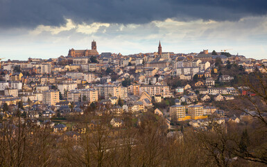 Fototapeta premium Panoramic view of French city of Rodez with tower of Cathedral and spire of church of Saint Amans in cloudy winter day