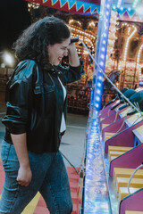 Fototapeta na wymiar Mujer joven latina juega en un parque de diversiones
