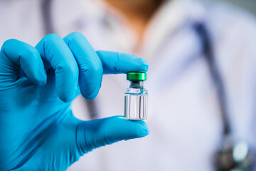 doctor holding vaccine bottle for injection