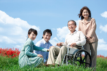 車椅子に座るシニア男性と笑顔の家族