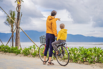 Obraz premium Father with his son having a weekend excursion on bike on a summer day in beautiful landscape