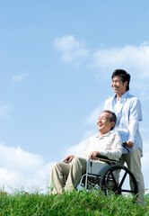 車椅子に座るシニア男性と笑顔の男性