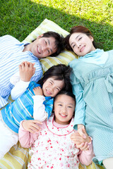 芝生に寝転ぶ家族