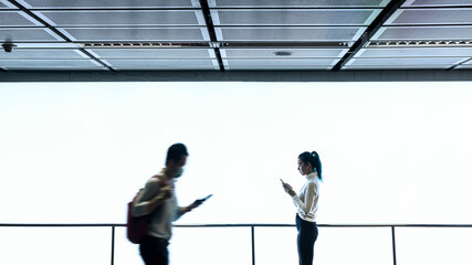 Girl texting on her phone while people are passing by