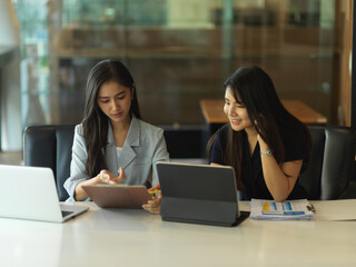 Two businesswomen consulting on their project in meeting room