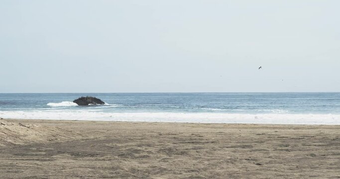 Pacific ocean waves crashing on sandy beach in Peru
