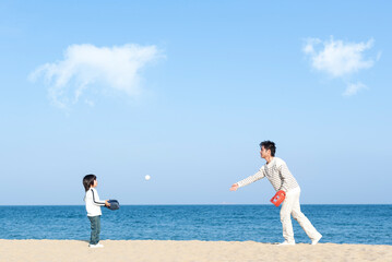 砂浜で野球をする親子