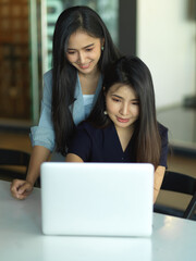 Portraits of kindly supervisor training new staff in office room