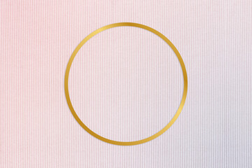 Gold round frame on a pinkish blue fabric background