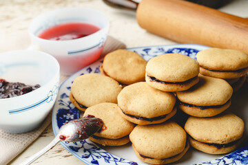 Homemade cookies with marmalade or fruit plum jam in a plate - close up front view baked sweet food traditional recipe - healthy eating concept