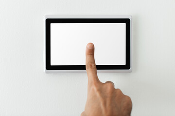 Finger pressing on smart home automation panel monitor