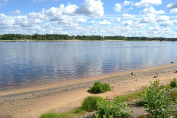 Summer landscape with a river and fluffy white clouds in the sky. Rybinsk, Russia, Volga river.