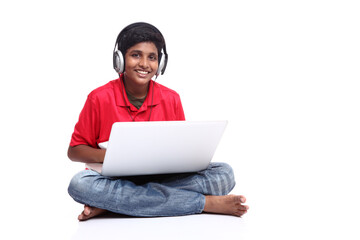 teenager boy is sitting with laptop on white background.