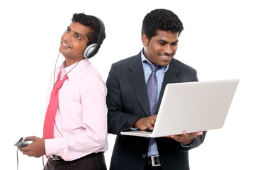 Obraz premium Two indian business people, one is working other one is listening music on white.