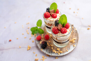 Greek yogurt raspberry parfaits in glass jars, small healthy dessert 