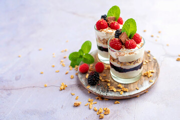 Greek yogurt raspberry parfaits in glass jars, small healthy dessert 
