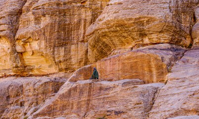 Jordan, Wadi Musa, Bedouin man is praying  in the rocks.