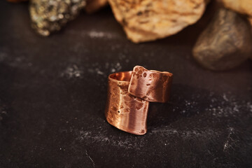 Copper ring with tubular shape handmade on a black textured background. Jewelry product. Special gifts       