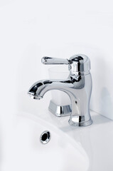 Contemporary new chrome bathroom faucet. Vertical photography.