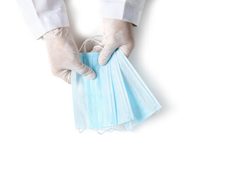 Doctor hands in medical gloves holding surgical  protective mask isolated on white background. Prevent and help stop the coronavirus outbreak