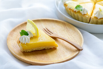 Lemon Tart citrus cake in wood dish and white cloth background,