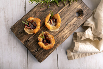 Fototapeta premium Brie bites with jam and nuts in crescent dough, mini appetizer dessert with cranberry or any jelly