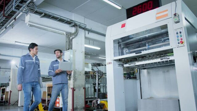 specialist worker engineer team control and operate printing package lable machine with computer screen with concentrate and focus industrial factory machinery ideas concept