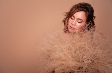 Portrait of beautiful woman in the studio with dry flowers. Pastel color of perfect make-up. Cosmetics