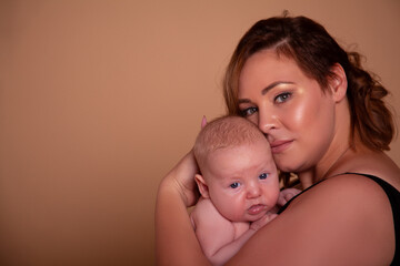 Overweight mother , with fat body after childbirth, holding newborn baby on the studio