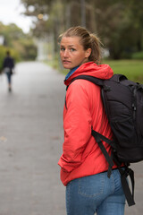 Female Student Looking Over Her Shoulder While Walking on Campus