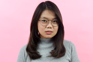 Natural face look at camera and smiling, Beautiful Asian (Indonesian) woman wearing a gray turtle neck shirt isolated on pink background