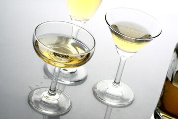 Glasses of alcohol drinks on white.